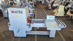 L-shaped packaging sealer with semi-automatic shrink tunnel.