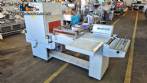 L-shaped packaging sealer with semi-automatic shrink tunnel.