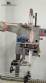 Label applicator machine with steam-operated shrink tunnel for sleeves.