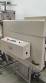 Label applicator machine with steam-operated shrink tunnel for sleeves.